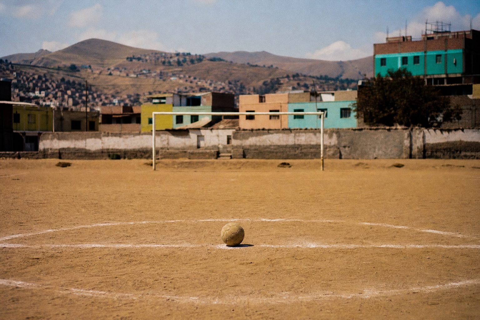 Worn ball on the centre spot of a dusty Latin American city pitch (picture made with AI)