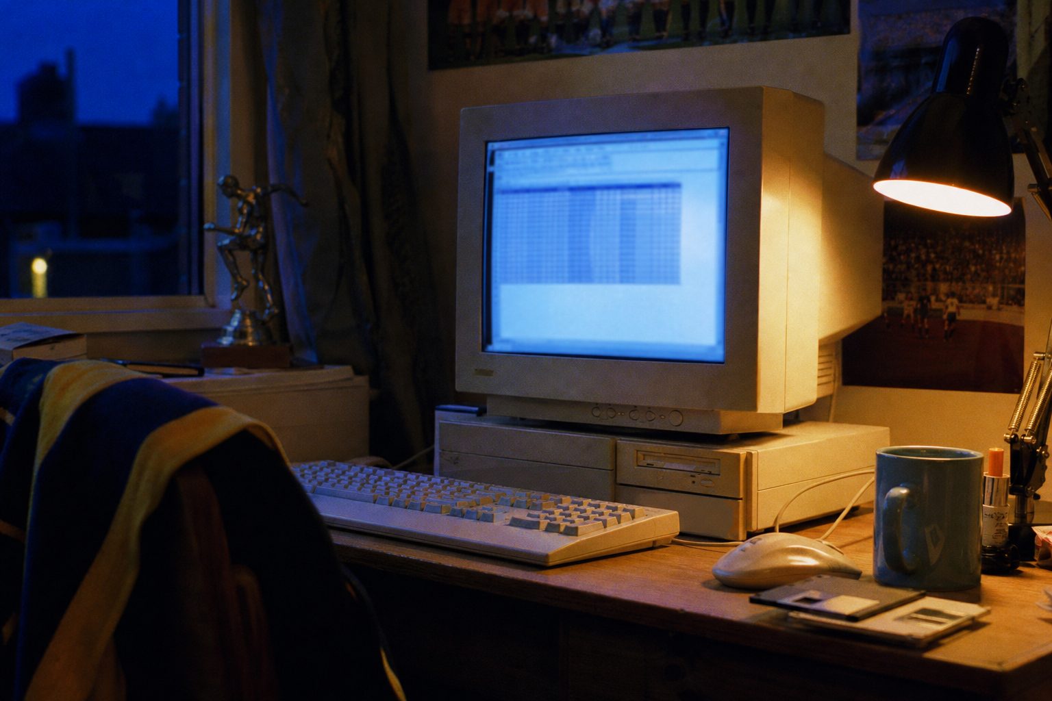 1990s beige computer glowing at night on a bedroom desk with a scarf on the chair (picture made with AI)