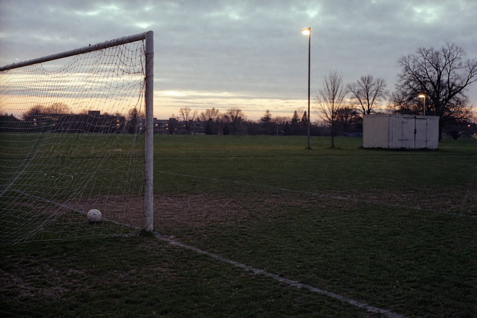 Empty Sunday-league pitch in south London at dusk (picture made with AI)