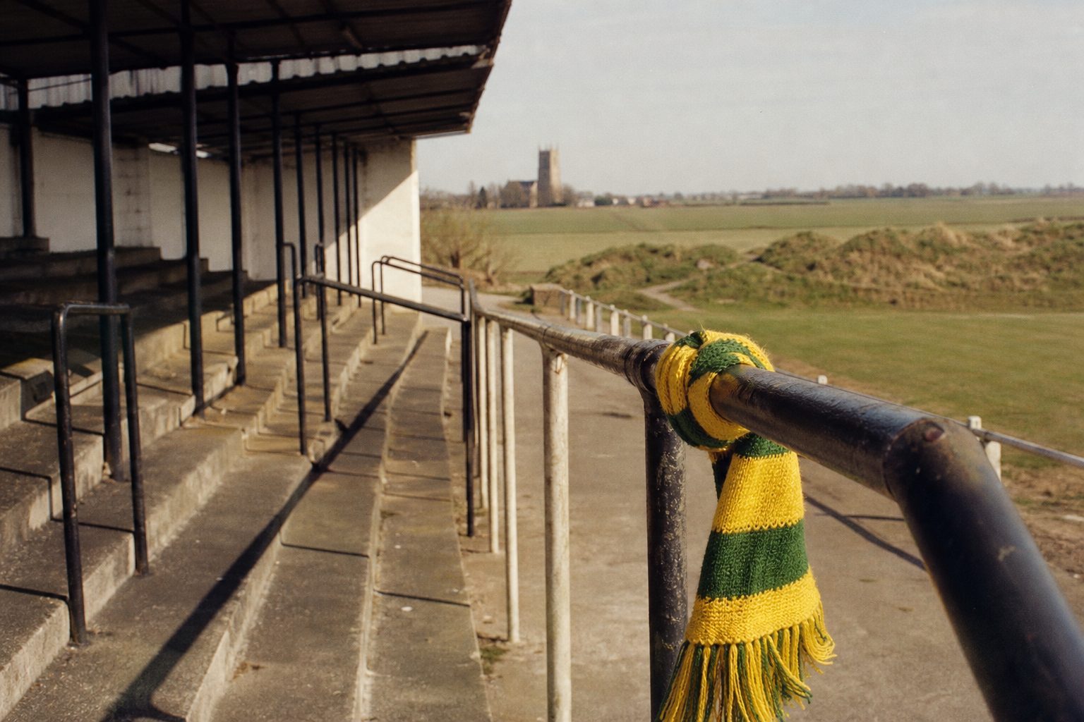 Yellow and green scarf tied to a railing on an old open terrace (picture made with AI)