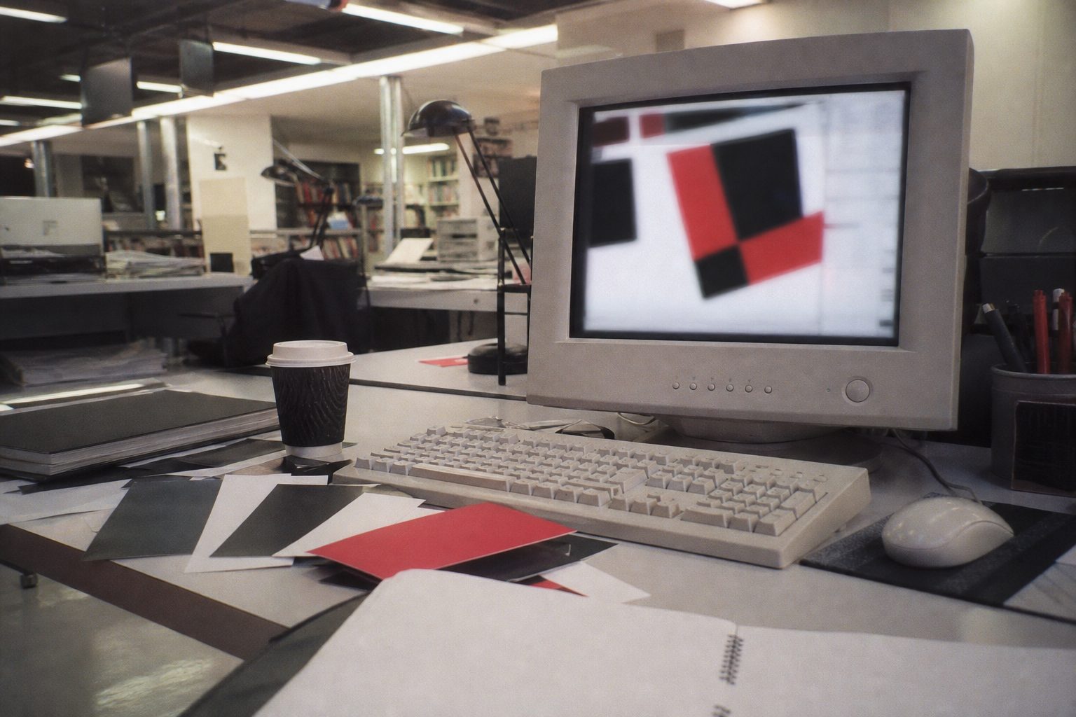 Early-2000s design desk with a glowing monitor and black, white and red colour swatches (picture made with AI)