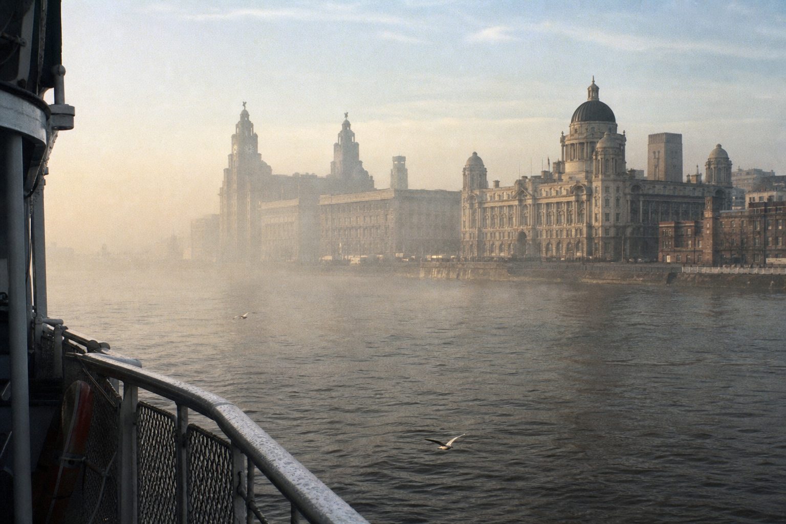 Misty river waterfront with domed Edwardian buildings seen from a ferry deck (picture made with AI)