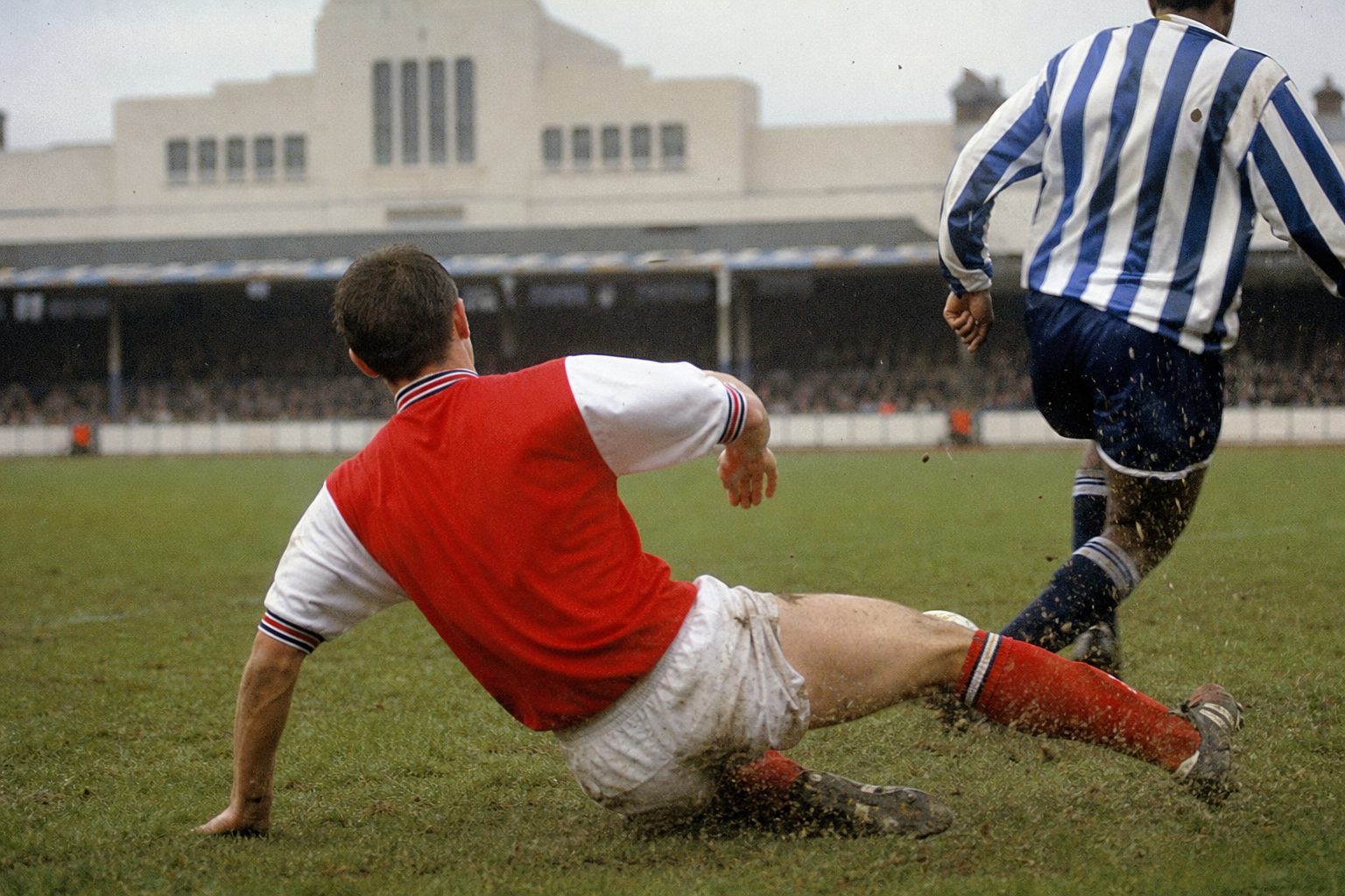 Defender in a plain red shirt with white sleeves sliding into a tackle (picture made with AI)