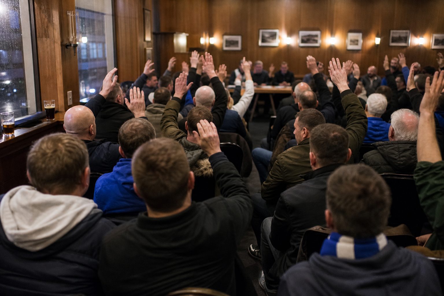 Football supporters raising their hands in a vote in a room above a pub (picture made with AI)