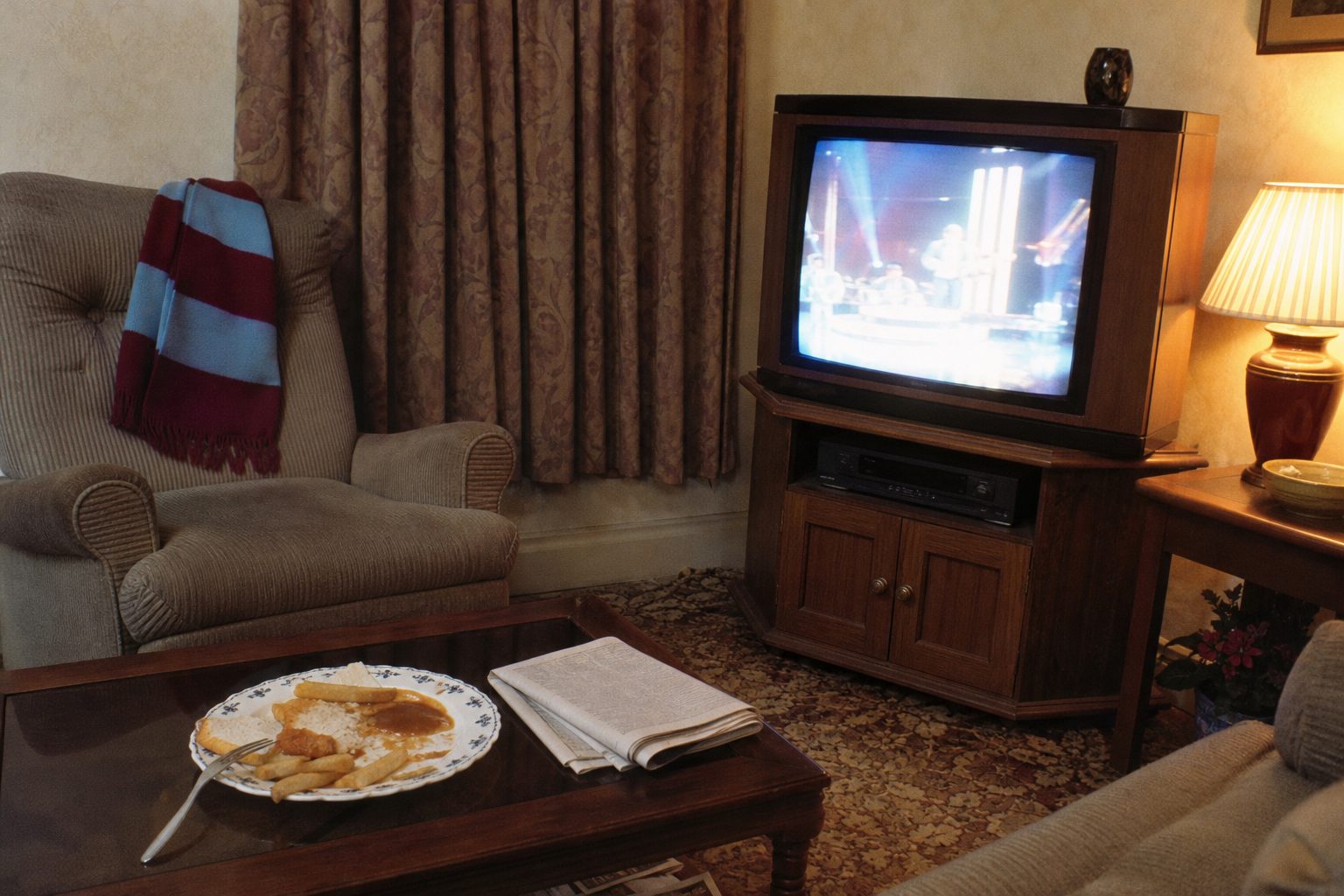1990s living room with a wood-effect television, fish supper and scarf (picture made with AI)